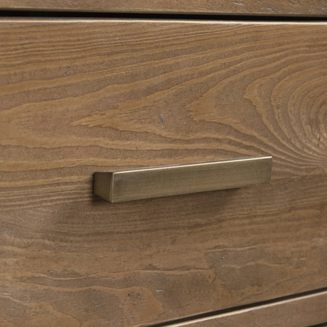Brass cabinet handle on a wooden drawer