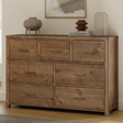 Wooden dresser with multiple drawers in a room setting.