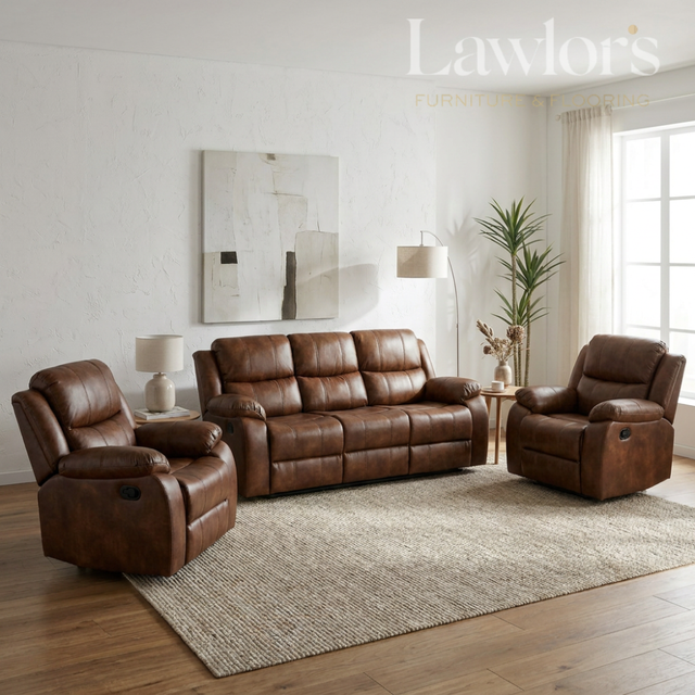 A tan PU leather 3+1+1 sofa set flanked in a bright, modern living room. The furniture is arranged on a textured beige area rug over a wood floor, with a side table, lamps, a potted plant, and abstract wall art in the background.