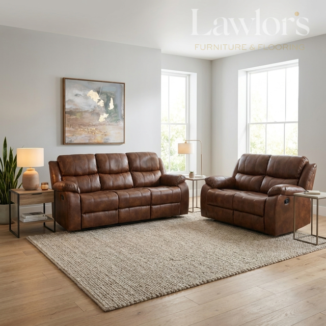 A tan PU leather 3+2 reclining sofa set arranged in a bright living room with wood floors, a large beige rug, side tables, lamps, and wall art.