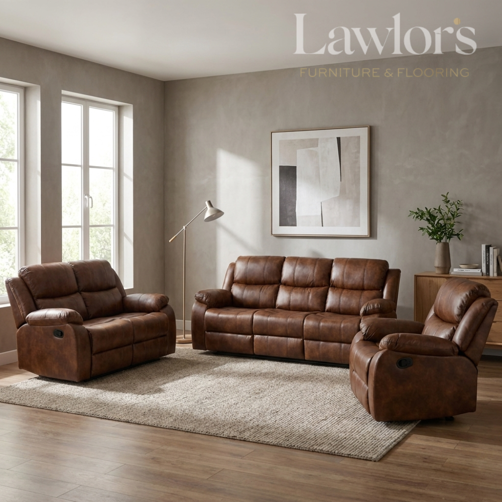 A tan PU leather 3+2+1 reclining sofa set arranged on a light rug in a staged living room. The room has textured gray walls, wood flooring, a floor lamp, and a framed abstract print.