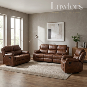 A tan PU leather 3+2+1 reclining sofa set arranged on a light rug in a staged living room. The room has textured gray walls, wood flooring, a floor lamp, and a framed abstract print.