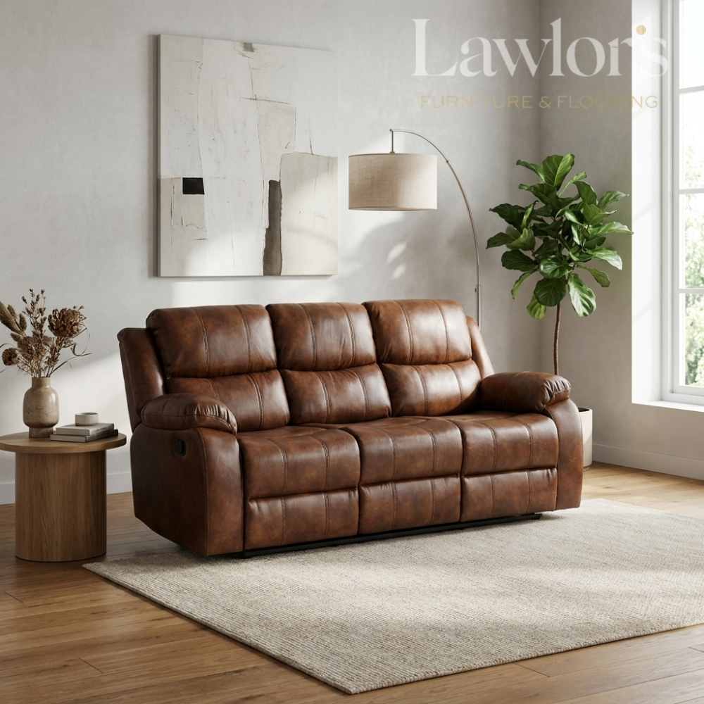 A tan PU leather 3 seater reclining sofa in a modern living room setting with a wooden floor, beige rug, side table, floor lamp, and potted plant.