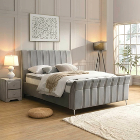 Modern bedroom with a striped bed pack, nightstand, and abstract art on the wall.