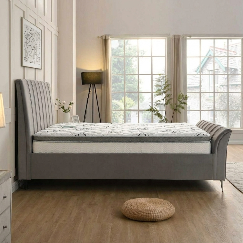 Gray upholstered bed pack with white mattress in a bright bedroom