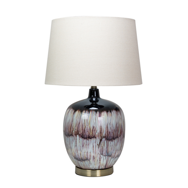 The Lara Table Lamp features a bottle-shape body, a mix of purple, lilac, pink, and damson hues, a ring of antique gold metal and gently flared white shade.