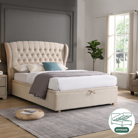 The Lily Gas-Lift Fabric Ottoman features a plush button accent, soft-touch beige fabric, storage convenience and stylish winged sides.