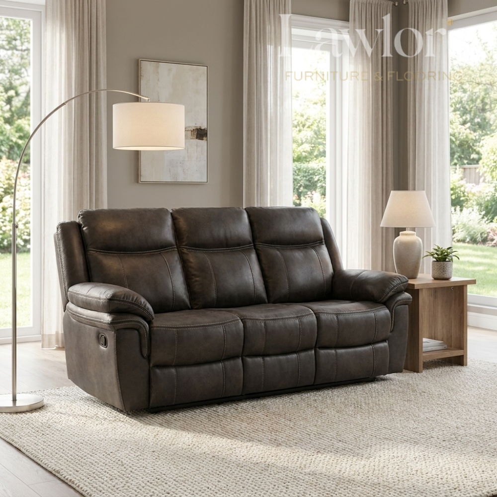 Grey leather 3 seater sofa in a living room setting with a lamp and window.