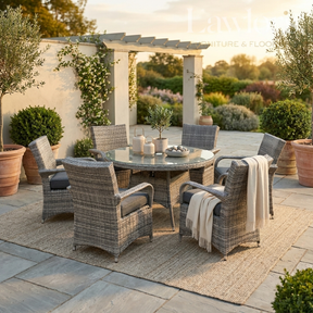 Outdoor garden furniture patio set with table and chairs on a stone patio with plants and a pergola in the background.
