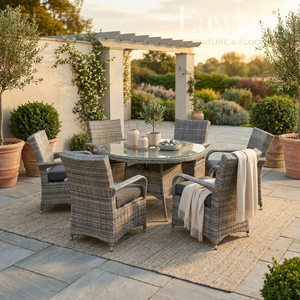 Outdoor garden furniture patio set with table and chairs on a stone patio with plants and a pergola in the background.
