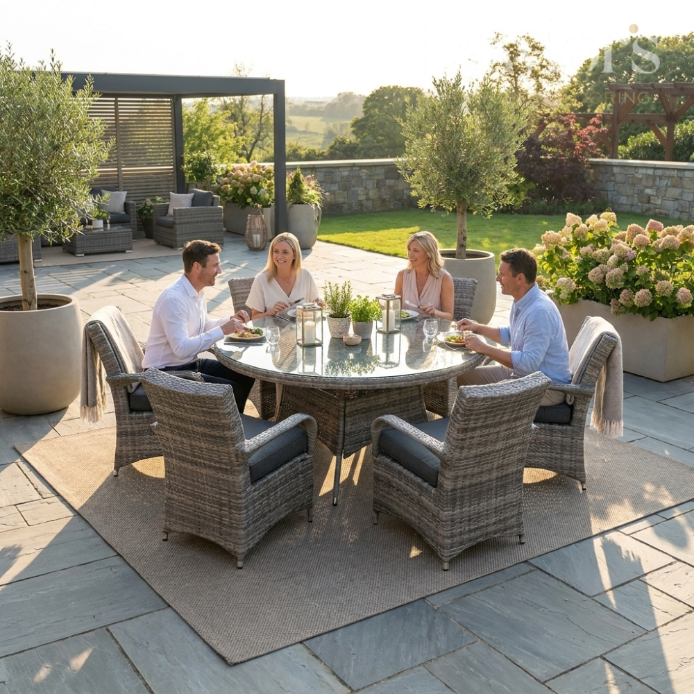 Four people sitting around a round outdoor garden furniture set on a patio.