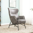The Mason Armchair in Charcoal features a curvy, edgy design with vintage-inspired leather upholstery providing stylish comfort.