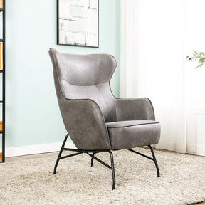 The Mason Armchair in Charcoal features a curvy, edgy design with vintage-inspired leather upholstery providing stylish comfort.