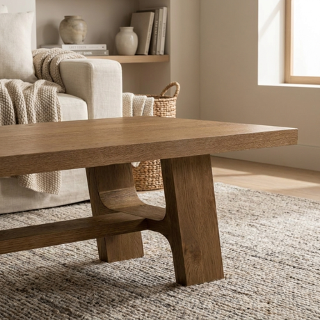 Wooden dining table in a room with a sofa and decorative items.