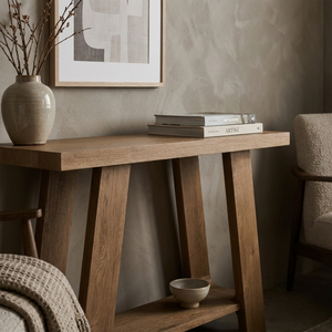 Wooden console table with decorative items against a neutral wall.
