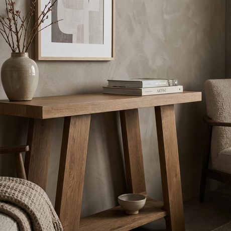 Wooden console table with decorative items against a neutral wall.