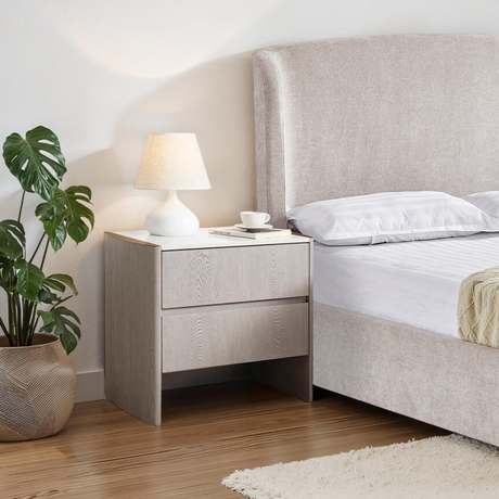 The Mondello 2 Drawer Bedside Table in Washed Oak features a luxurious sintered stone top, stainless steel accents and ample storage for a modern bedroom