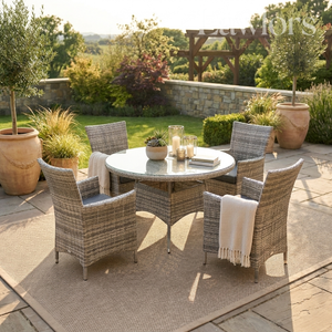 Outdoor garden furniture patio set with round table and chairs on a stone patio, surrounded by plants and garden.