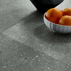 The Ninaventura Graphite Tile SPC Flooring features sleek tile design, waterproof mineral core, Titanium Nano finish and 25 year warranty