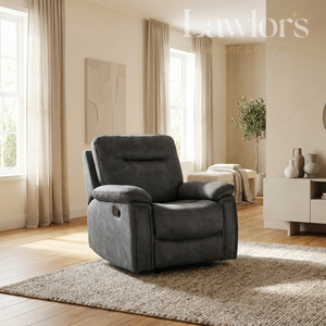 A dark gray upholstered recliner chair placed on a textured beige rug in a bright, modern living room with wood floors, curtains, and a sideboard.