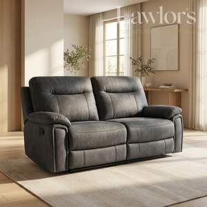 A dark gray reclining loveseat sofa in a modern, sunlit living room. The sofa features two plush back cushions, padded armrests, and a low-profile rectangular seat.