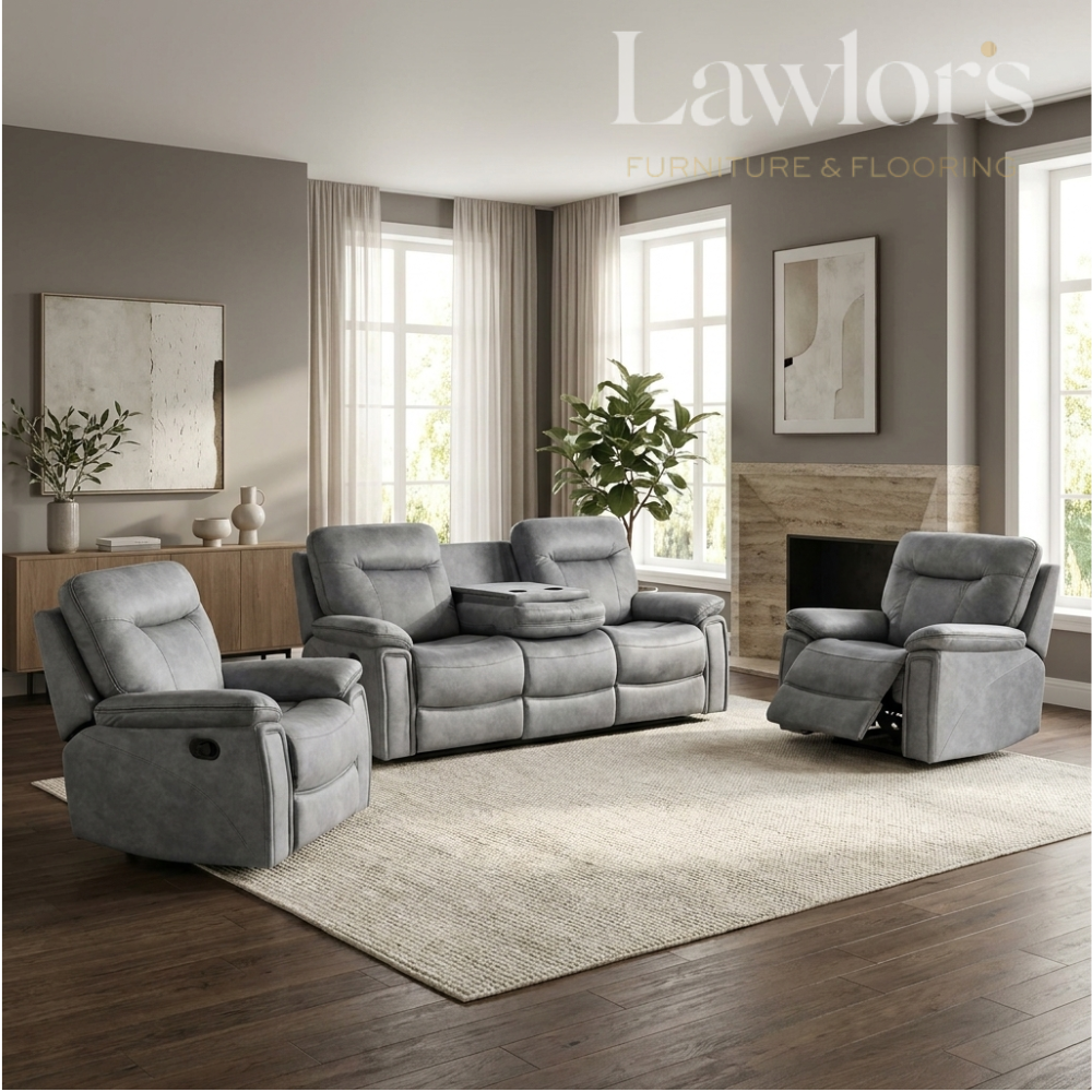 A gray upholstered living room furniture set in a staged modern living room, including a recliner, a three-seat sofa, and a matching recliner, with a large light rug, wood floors, windows, and wall art. 