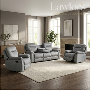 A gray upholstered living room furniture set in a staged modern living room, including a recliner, a three-seat sofa, and a matching recliner, with a large light rug, wood floors, windows, and wall art. 