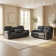 A dark gray two-piece recliner set consisting of a loveseat and a matching single-seater chair, styled in a modern, sunlit living room with beige walls, a light rug, and wood floors.
