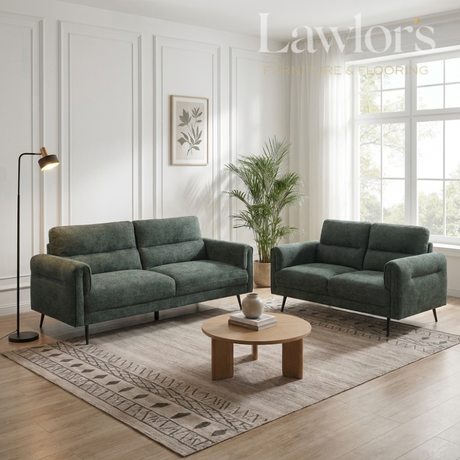 Green 3+2 sofa set in a living room with a coffee table and decorative elements.