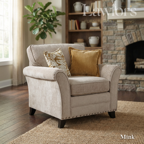 Mink fabric armchair with decorative pillows in a living room setting