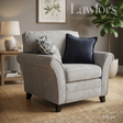 Silver fabric armchair with decorative pillows in a living room setting