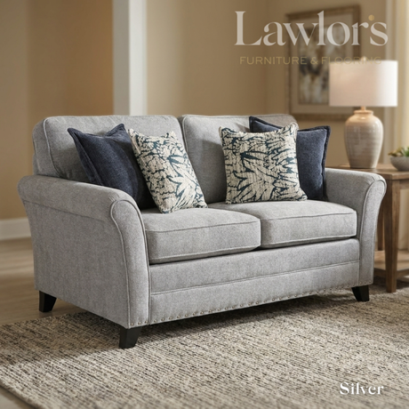 Silver 2 seater fabric sofa with decorative pillows in a living room setting