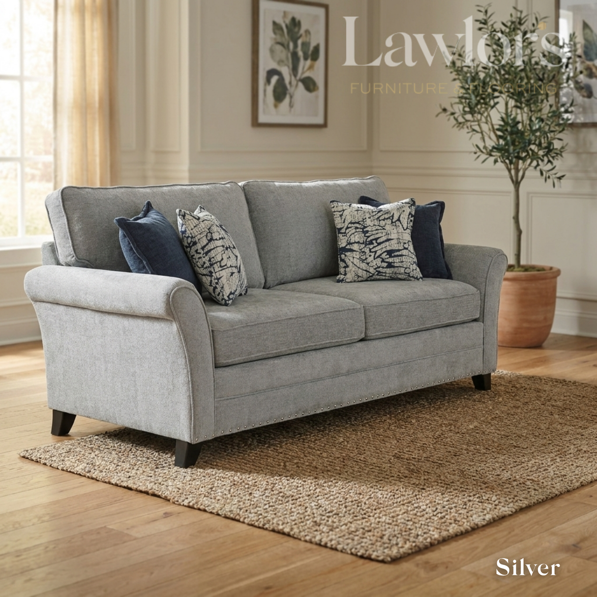 Silver 3 seater fabric sofa with decorative pillows in a living room setting