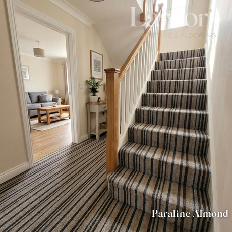 Staircase with striped carpet in a home interior, featuring a mirror and furniture.