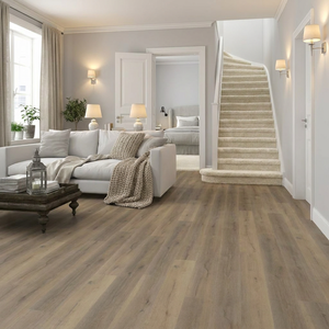 Living room with laminate flooring, carpet, white sofa, and staircase in the background