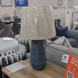 The Ridge Blue Ceramic Table Lamp 58cm features a circular textured base and cream shade with a 58cm tall lamp that adds style and warmth to any room