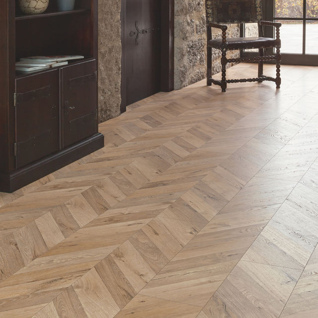 Rochesta Oak Laminate Flooring 8mm in chevron style featuring AC4 durability, easy installation, and a warm rustic oak finish.