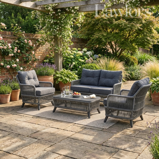 Outdoor garden furniture patio set with gray cushions in a garden setting