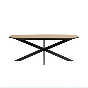 The Sadia Oval Dining Table in Oak features a durable, heat, stain, and scratch-resistant melamine top with a black metal base.