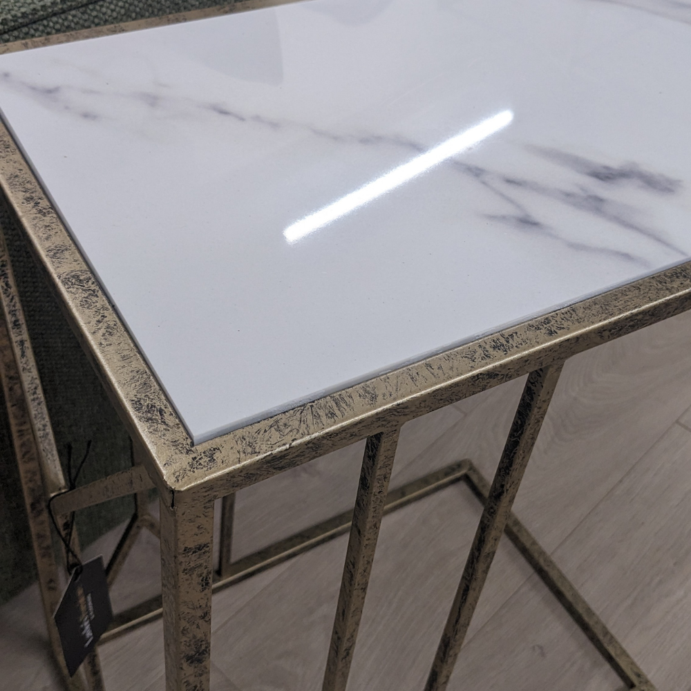 The Saloman Marble Top Accent Table features black and gold frame with a marble inspired top for a compact versatile piece, a timeless addition to any room