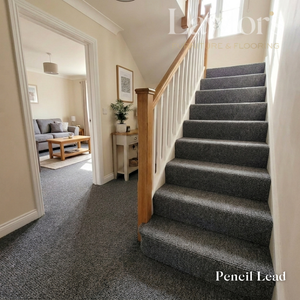 Staircase with gray carpet leading to a living room