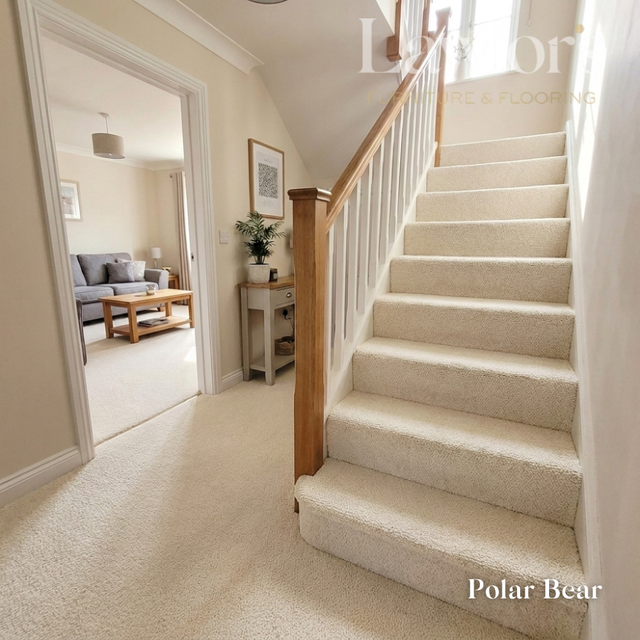 Staircase with white carpeted steps leading to a living room