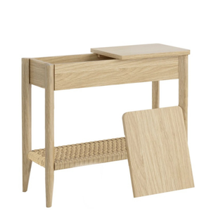 A light natural oak side table with an open top drawer, a woven rattan shelf, and a separate matching wood panel leaning against it, shown on a white background.