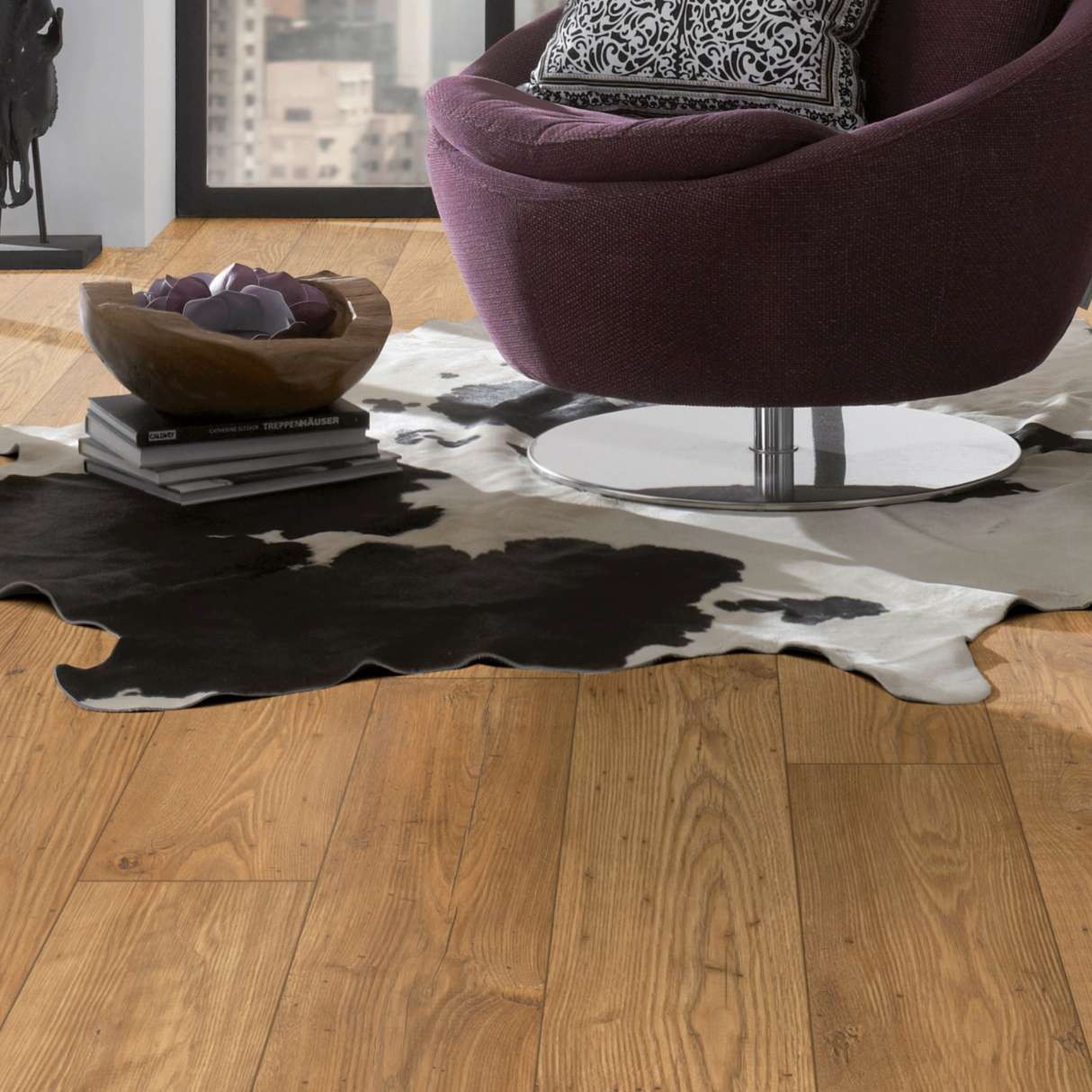 Modern interior with a purple chair on a cowhide rug over laminate floor