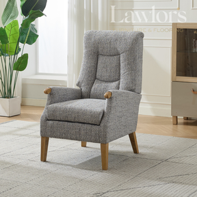 Grey armchair in a room with a plant and a cabinet.
