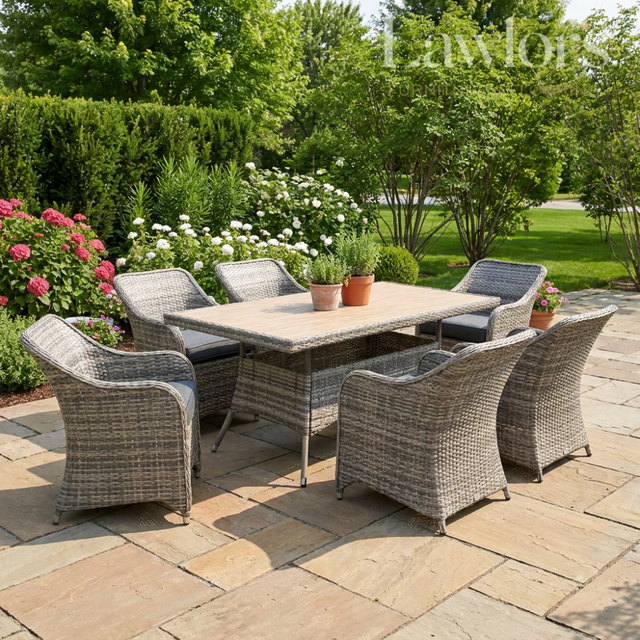 Outdoor garden furniture patio set with table and chairs on a stone patio, surrounded by greenery.