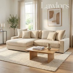 Beige sectional sofa in a living room with a coffee table and decorative items.