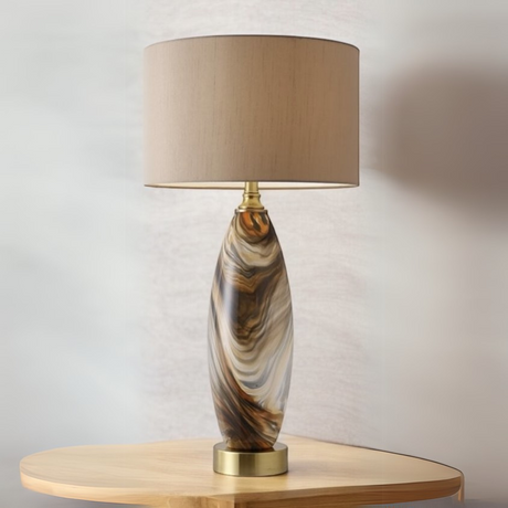 For a refined, artistic touch, the Zamora Glass Table Lamp (82cm) has a round, straight shade, a gold metal base, and a gorgeous brown twirl design.