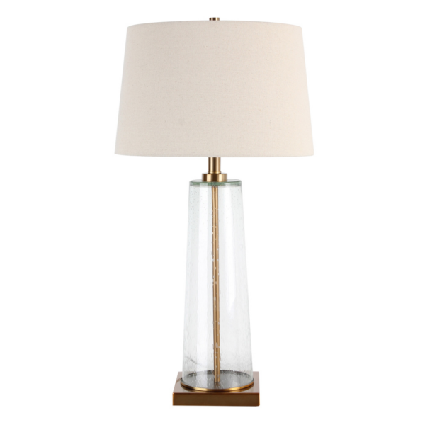 The elegant Amara Table Lamp Bubble Glass features a distinctive slanted base crafted from bubbled glass and brass fitting